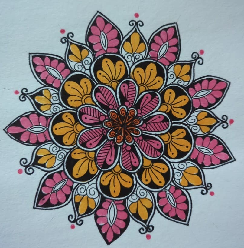 A hand-painted mandala design in pink, gold and black on paper, an example of mandala art